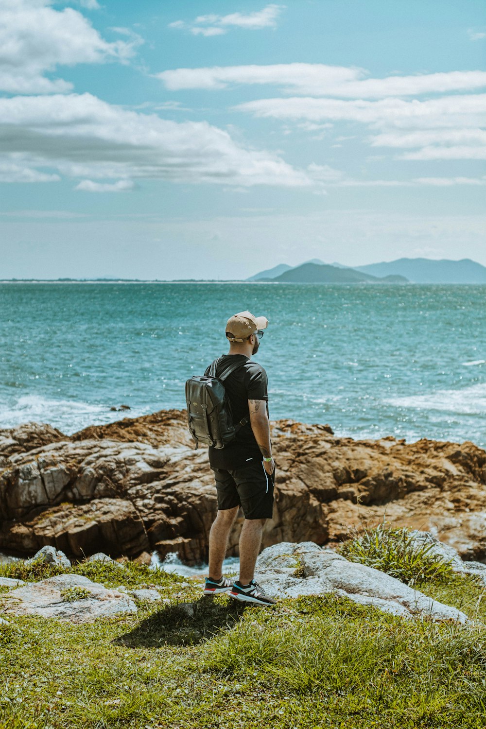 a man standing on a rock overlooking the ocean