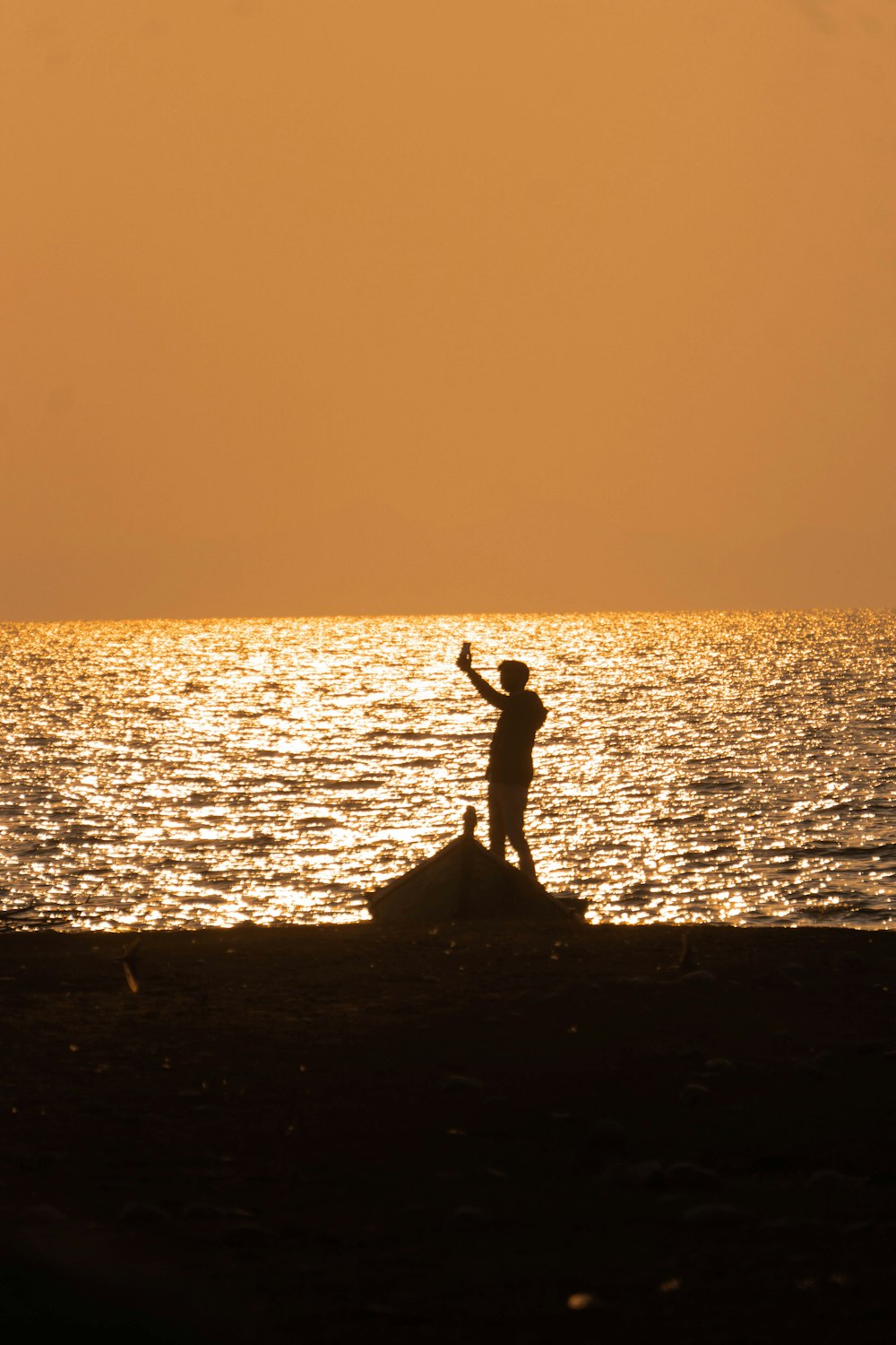 a person standing on a rock in front of a body of water