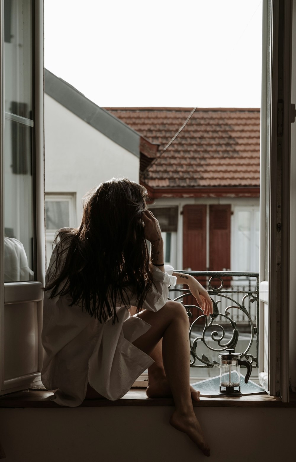 a woman sitting on a window sill