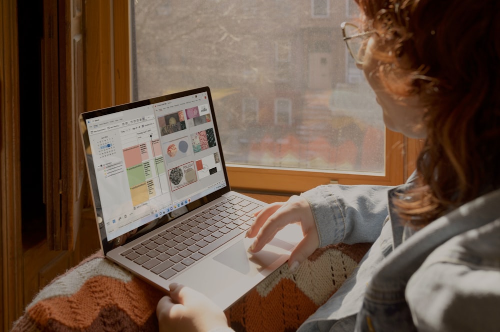 a woman sitting on a couch using a laptop computer