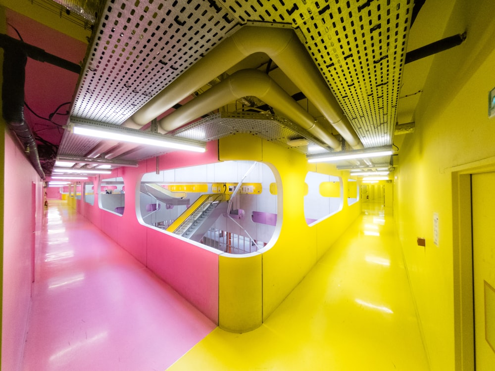 a yellow and pink hallway with a staircase