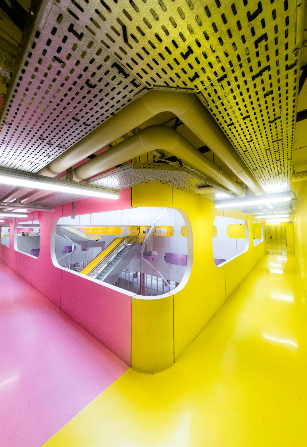 a yellow and pink subway station with a ramp