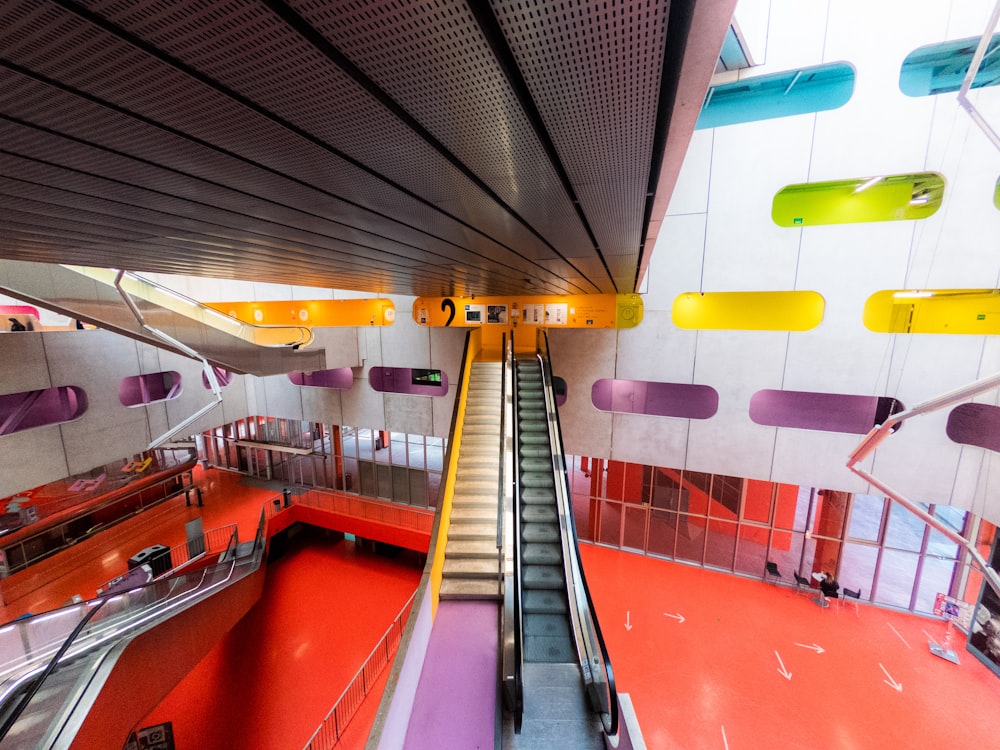 an escalator in a building with colorful walls