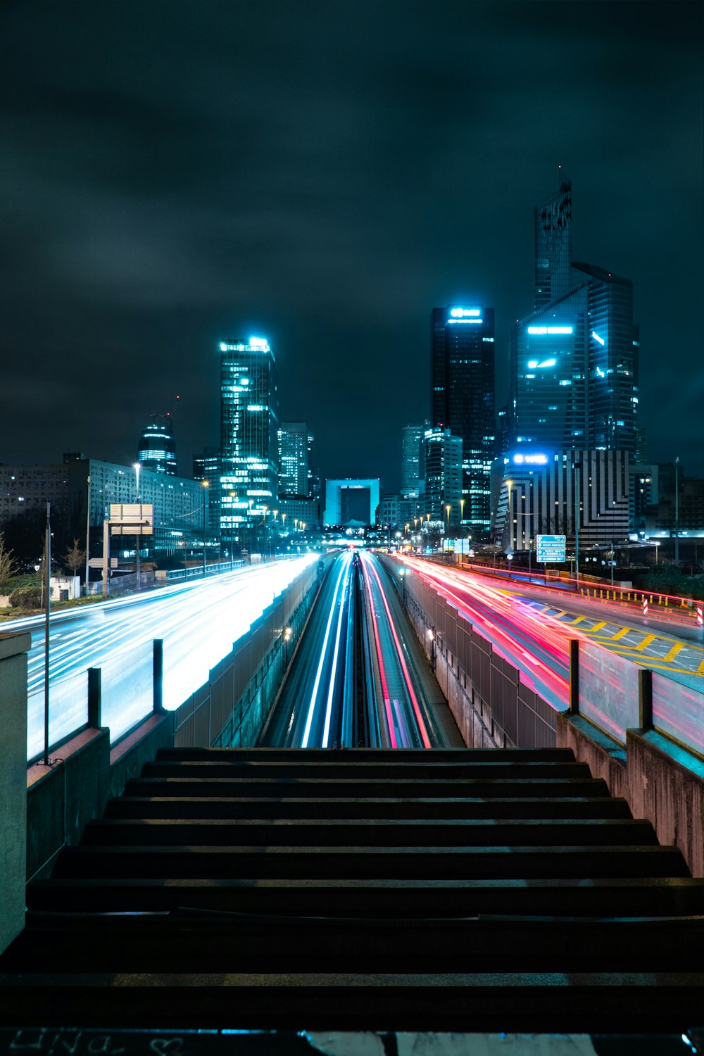 a view of a city at night from the top of a flight of stairs