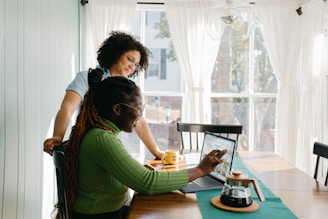 An author and editor discussing a draft over coffee in a bright room.