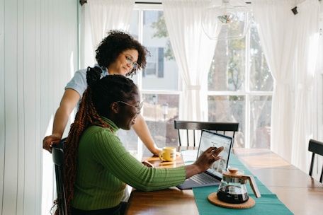 A friendly real estate agent discussing property plans with a young couple in a sunlit office.