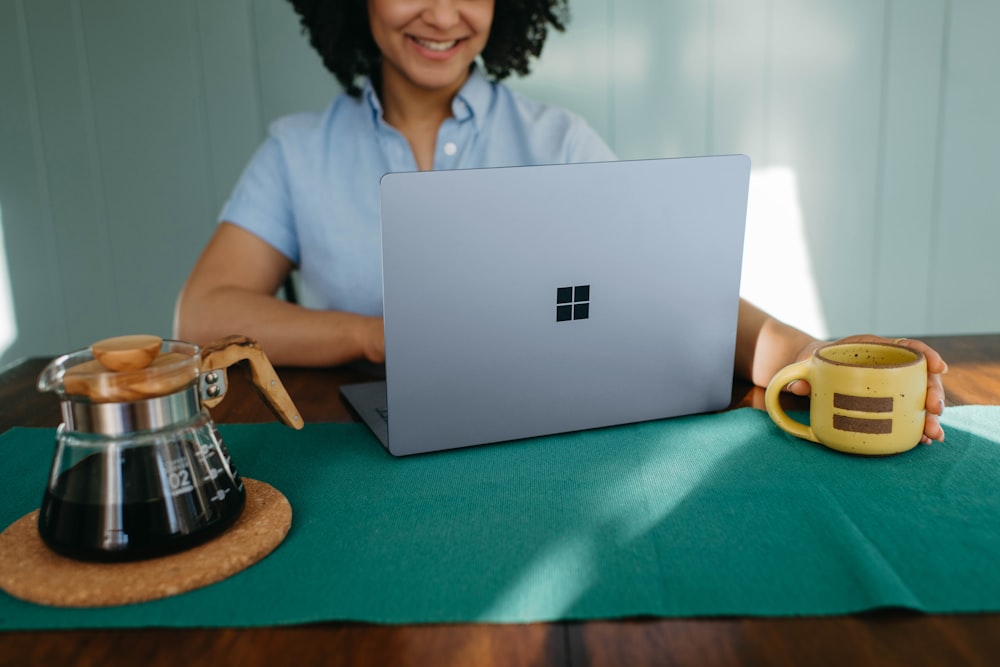 a woman sitting at a table with a laptop