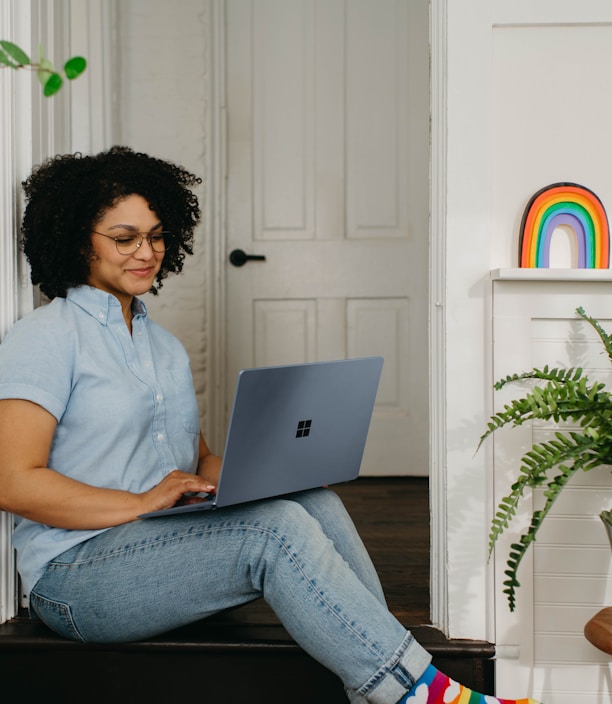 a woman sitting on the floor using a laptop