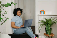 a woman sitting on the floor using a laptop