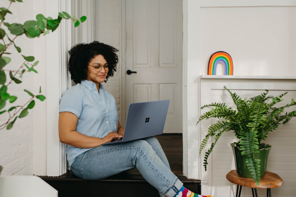 a woman sitting on the floor using a laptop