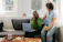 A happy couple relaxing on a plush Sitwell Furniture sofa in a cozy, sunlit living room.