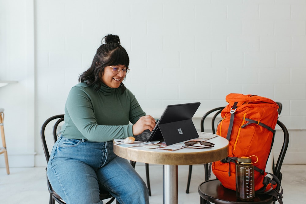 a woman sitting at a table with a laptop