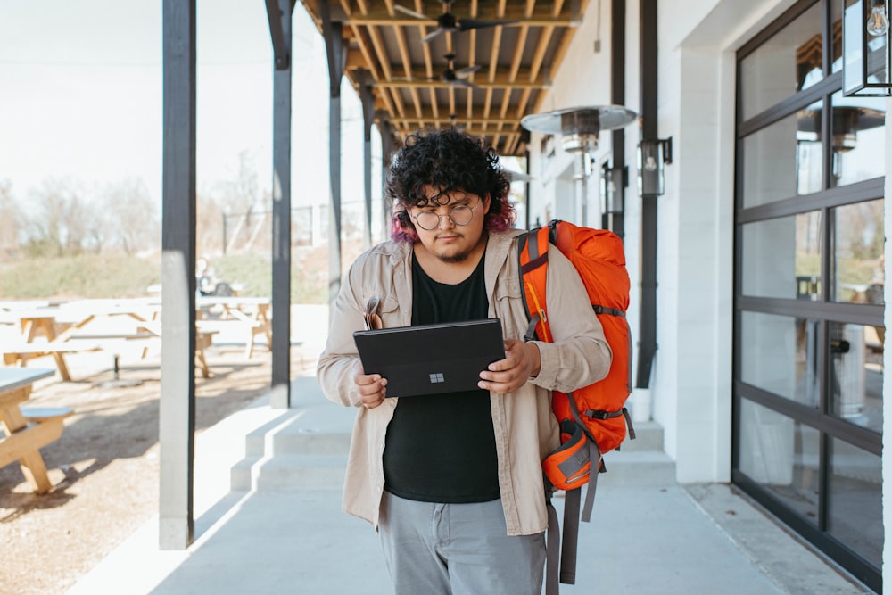 une personne avec un sac à dos et un ordinateur portable