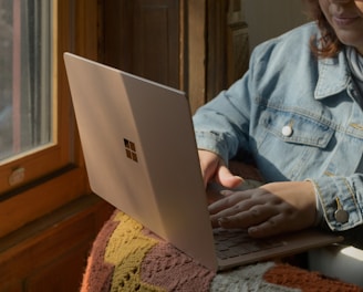 a woman sitting in a chair using a laptop computer