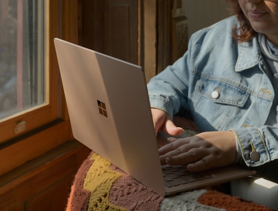 a woman sitting in a chair using a laptop computer