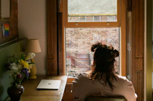a woman sitting in a chair looking out a window