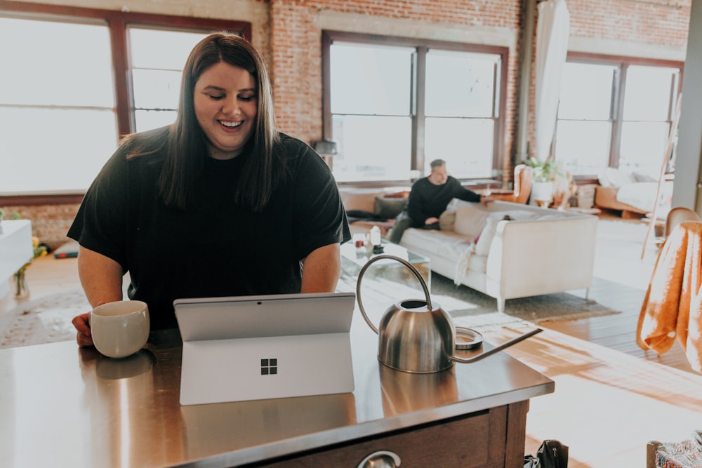 a woman sitting at a table with a laptop