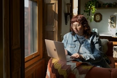 a woman sitting on a couch using a laptop computer