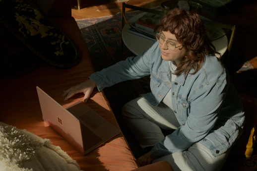 a woman sitting at a table using a laptop computer