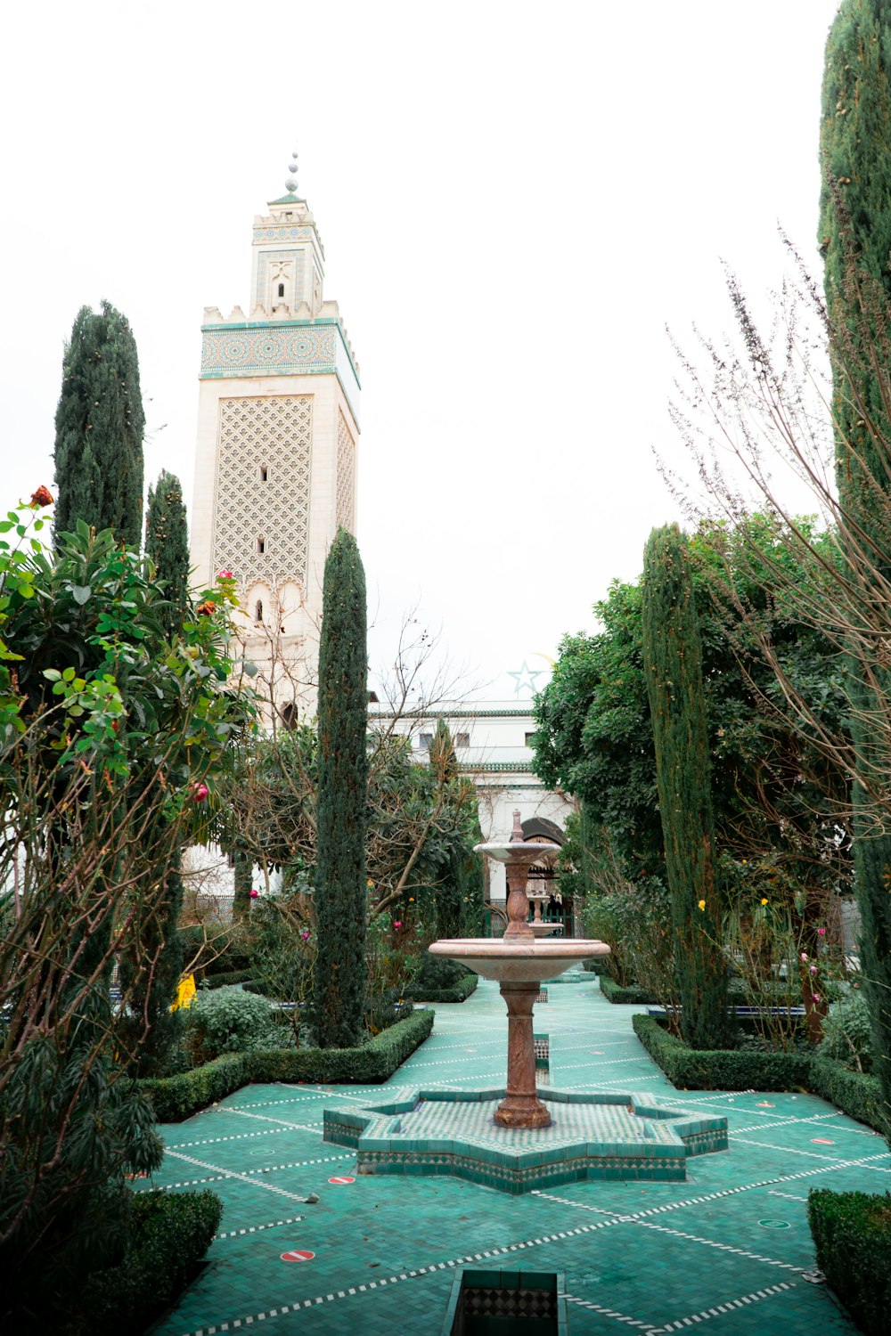 a courtyard with a fountain surrounded by trees