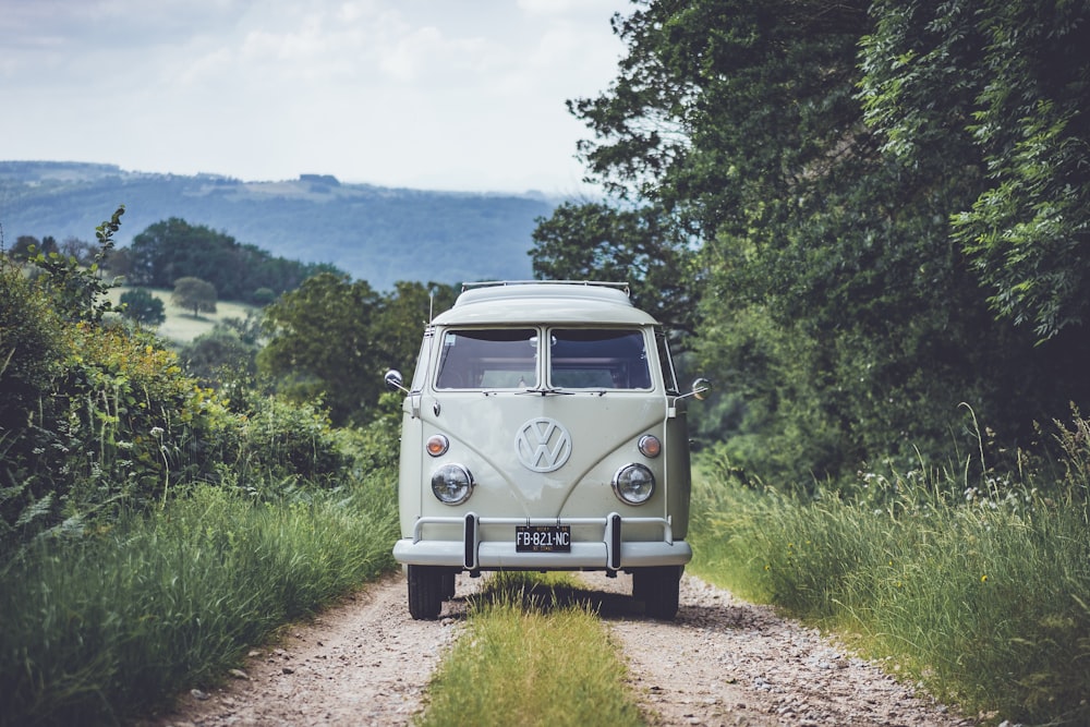 an old vw bus is parked on a dirt road