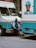 a man sitting on the side of a blue and white truck