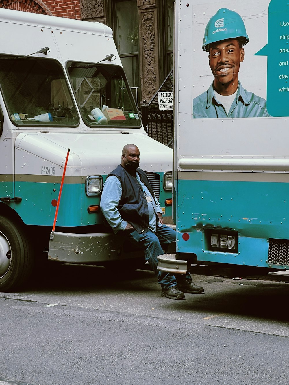 a man sitting on the side of a blue and white truck