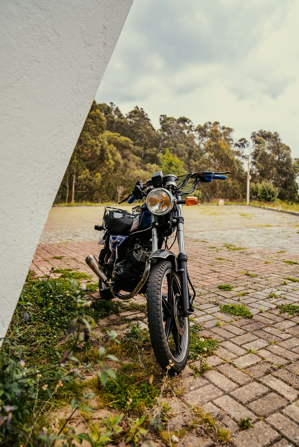 a motorcycle parked on a brick road next to a building