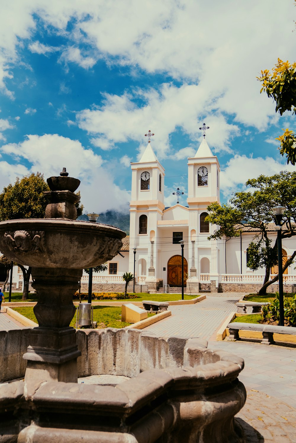 a fountain in front of a church with a clock tower