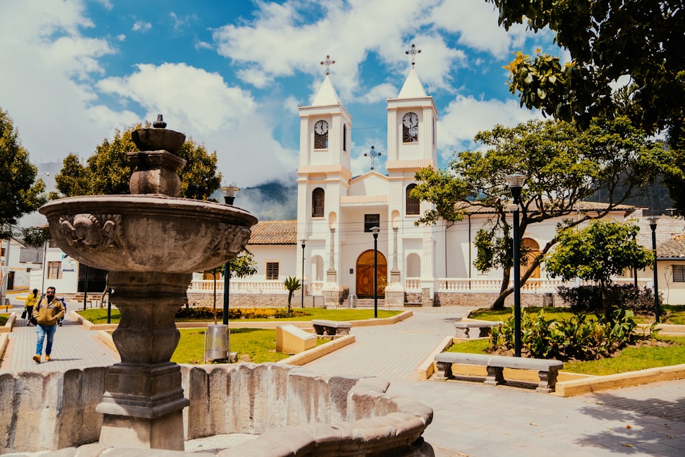 a large white church with a fountain in front of it