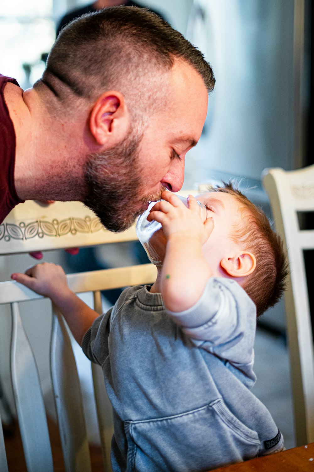 a man feeding a baby with a bottle of milk