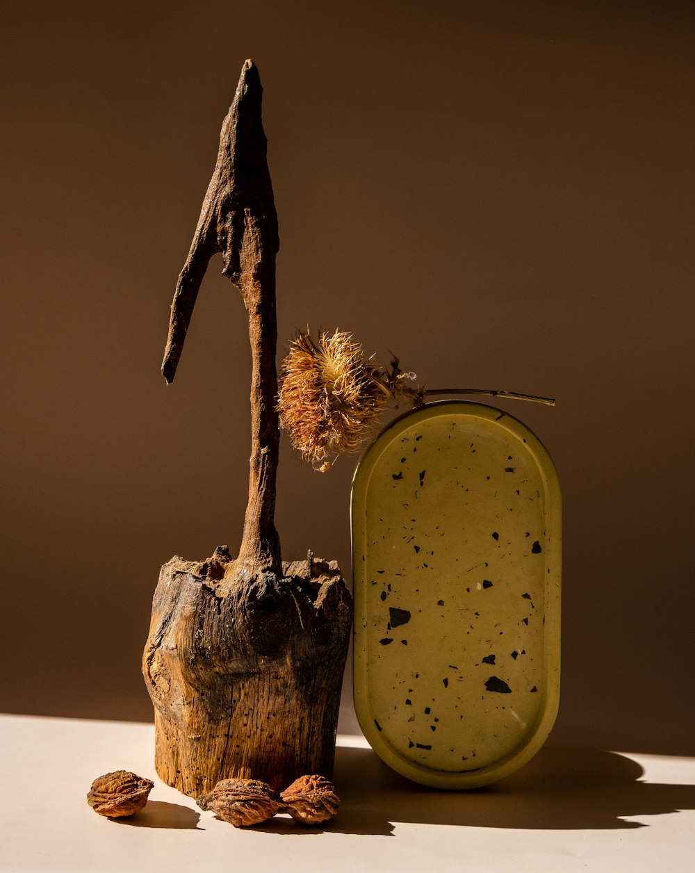 a piece of wood sitting next to a container of nuts