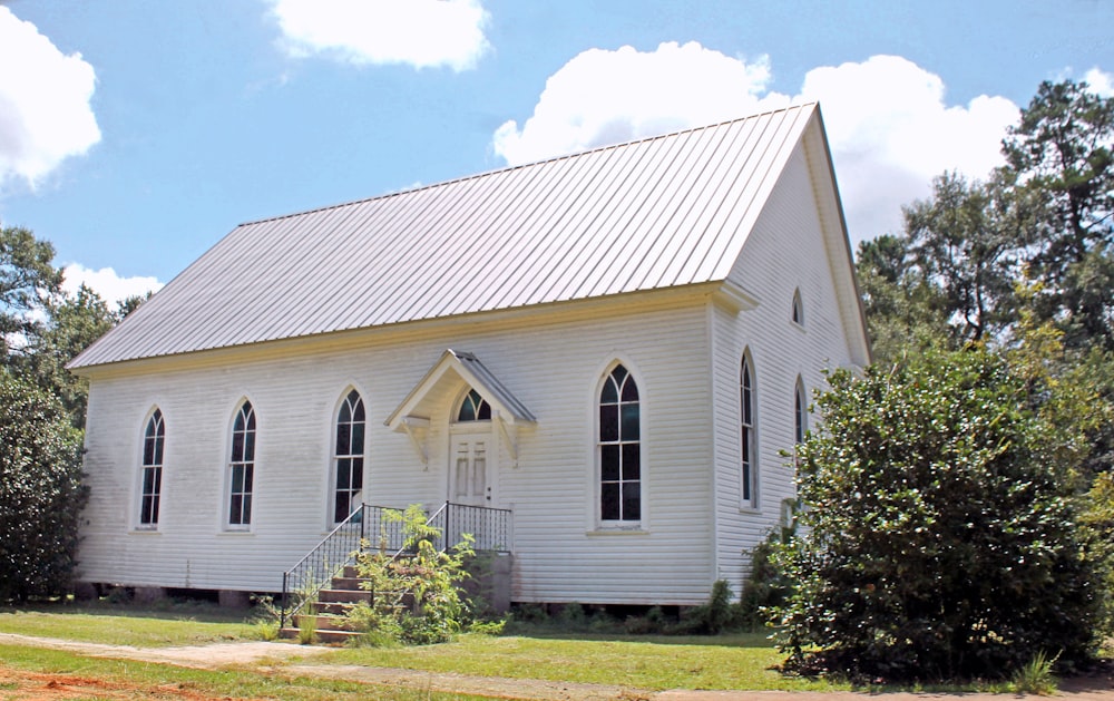 a white church with a metal roof and a steeple