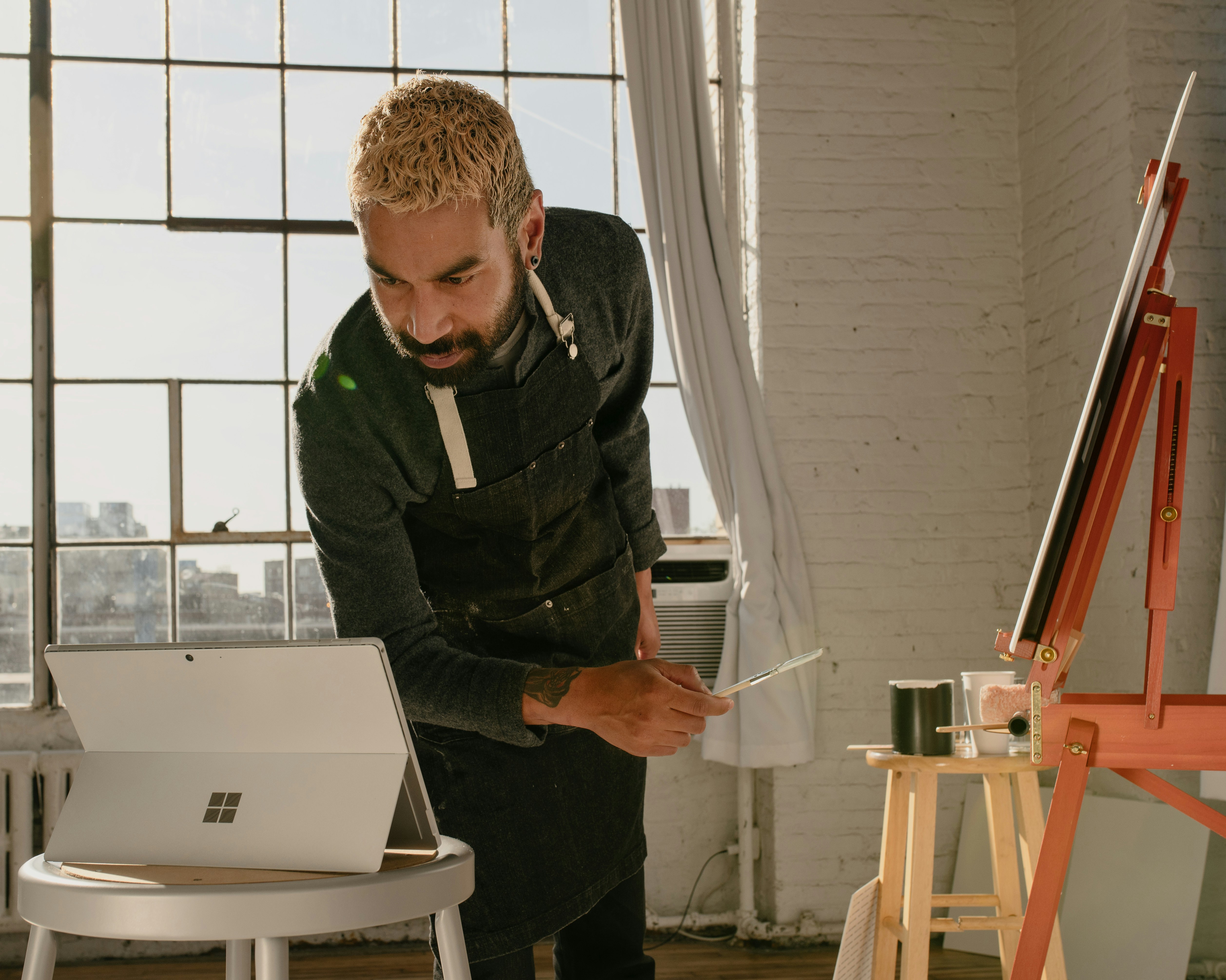 a man is painting a picture on a laptop