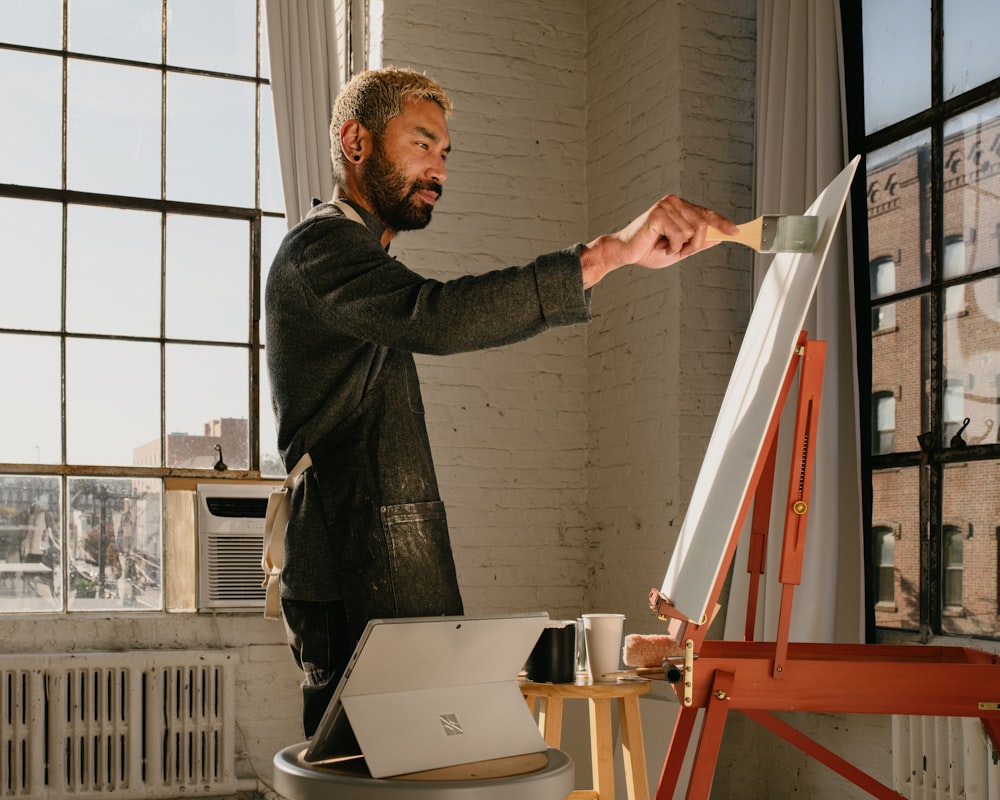 a man is painting a picture on a easel