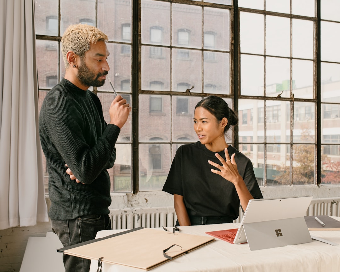 a man standing next to a woman at a table,