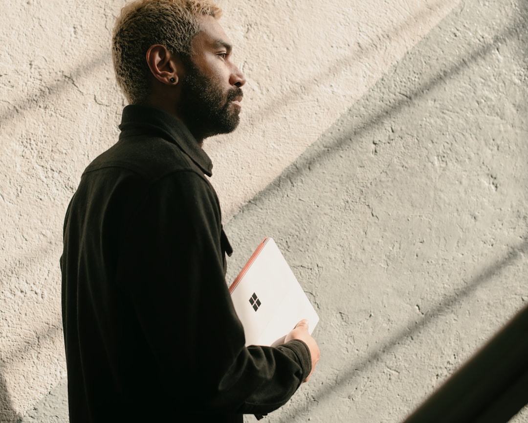a man with a beard is holding a folder,