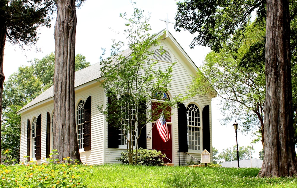 a small white house with a flag on the front of it