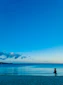 a person standing on a beach flying a kite