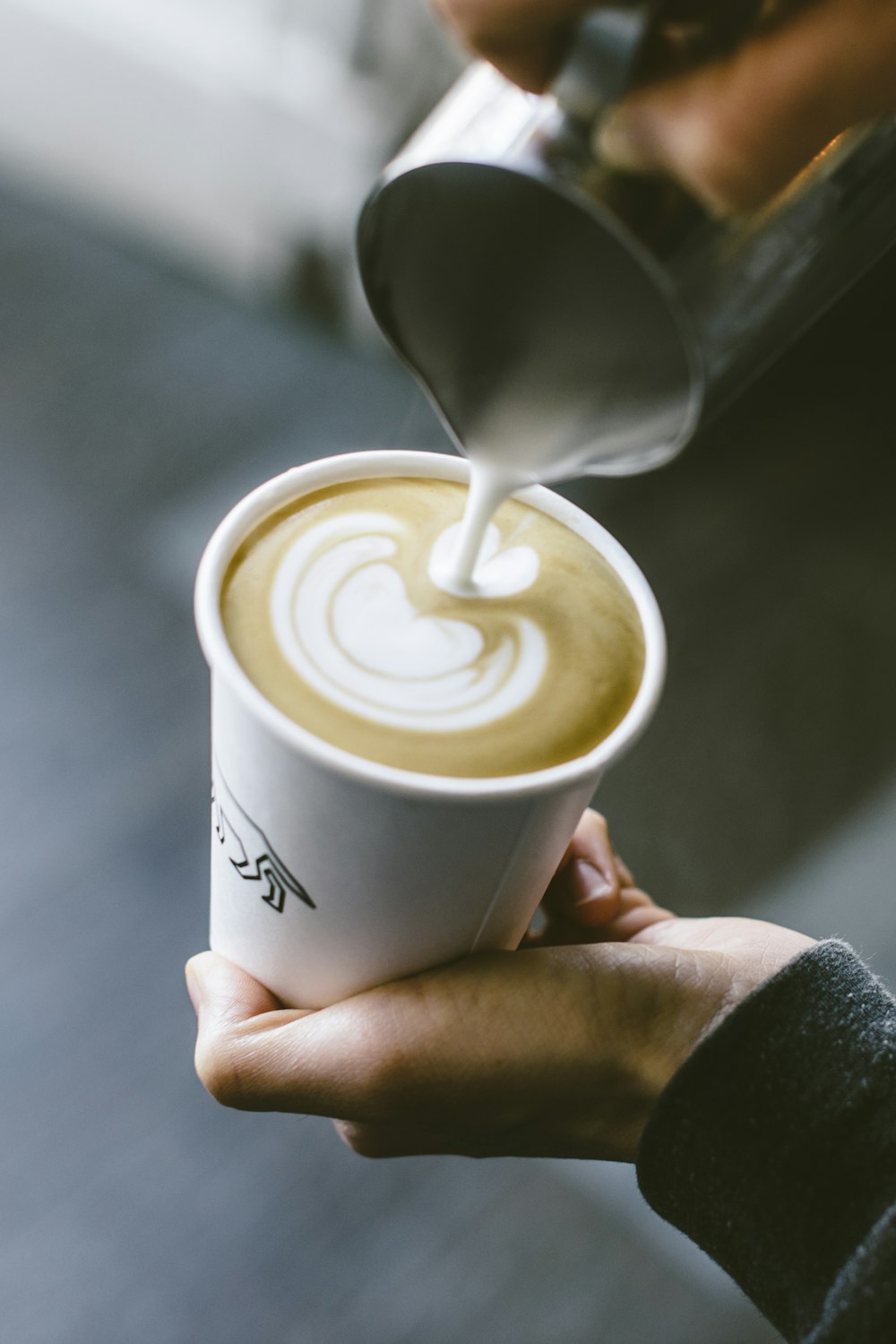 a cup of coffee being poured into a cup