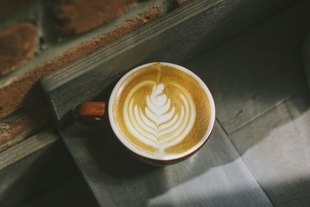 a cappuccino with a leaf design on it