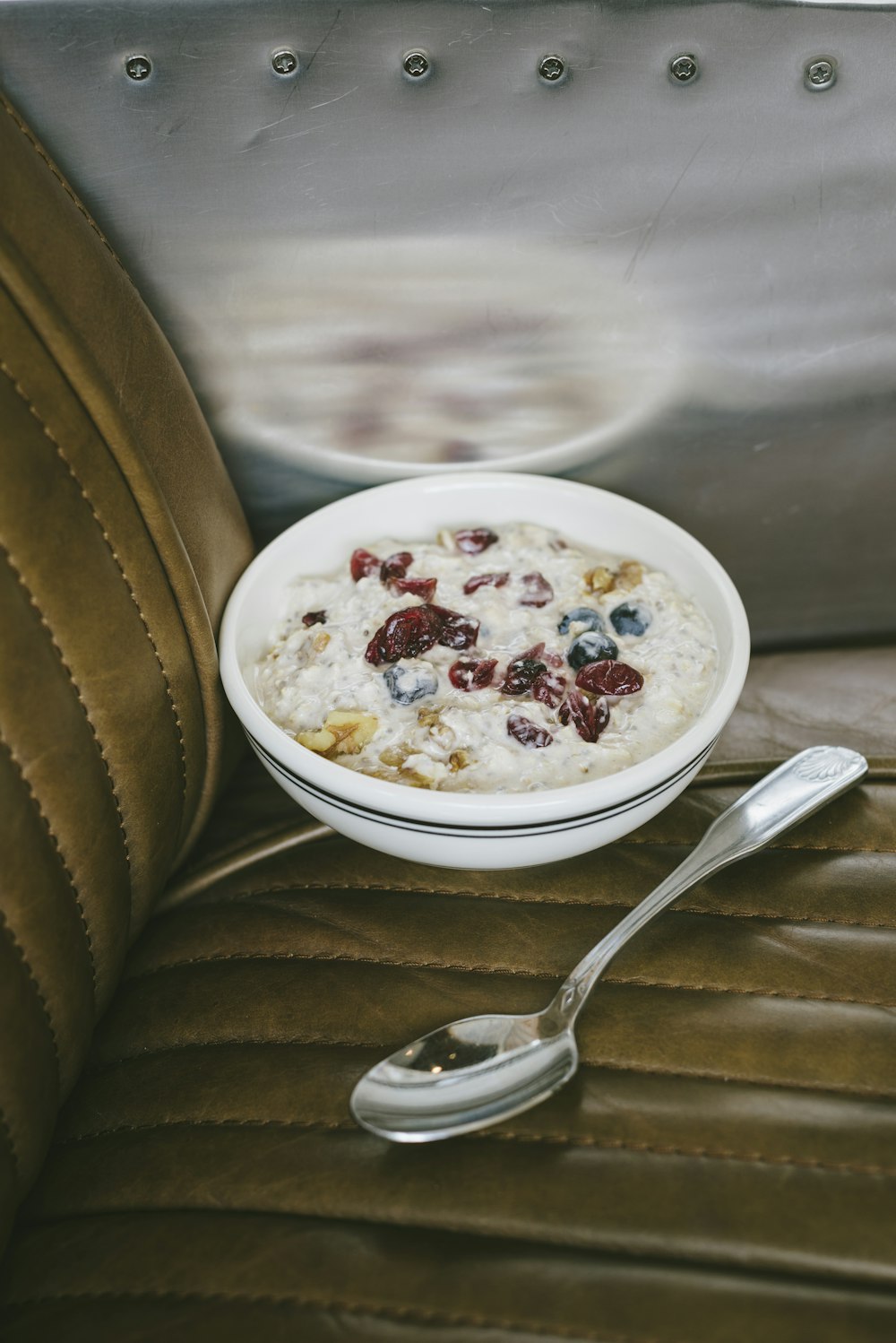 a bowl of oatmeal and a spoon on a seat