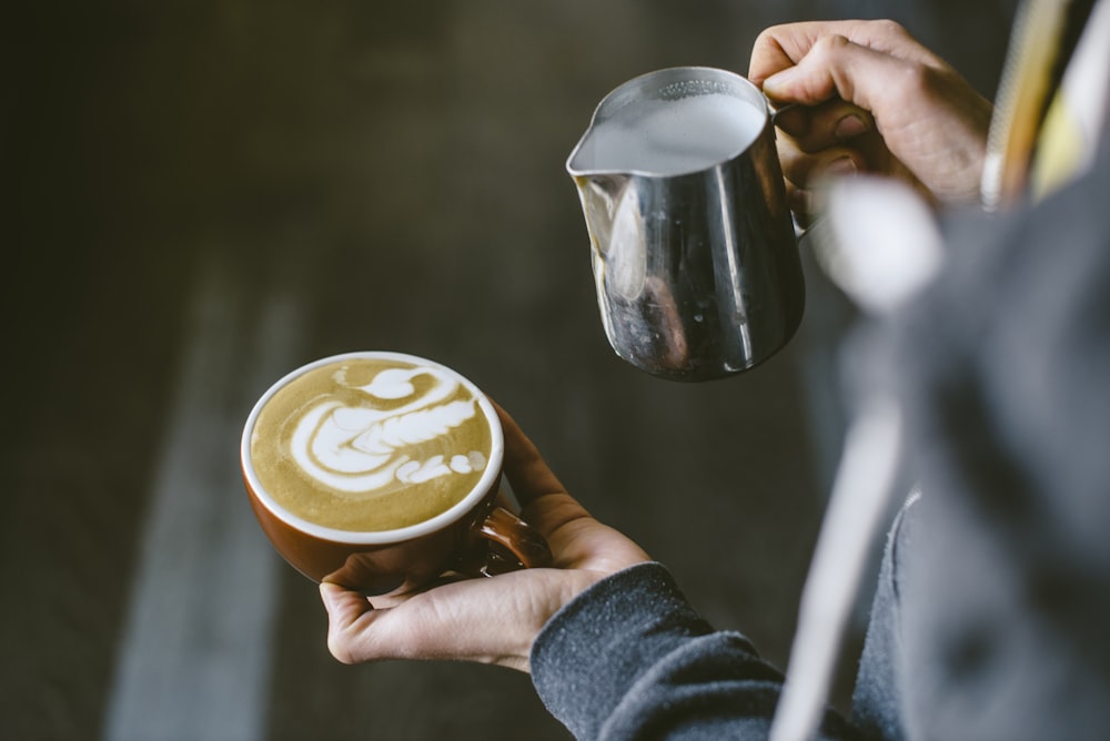 a person holding a cup of coffee in their hand