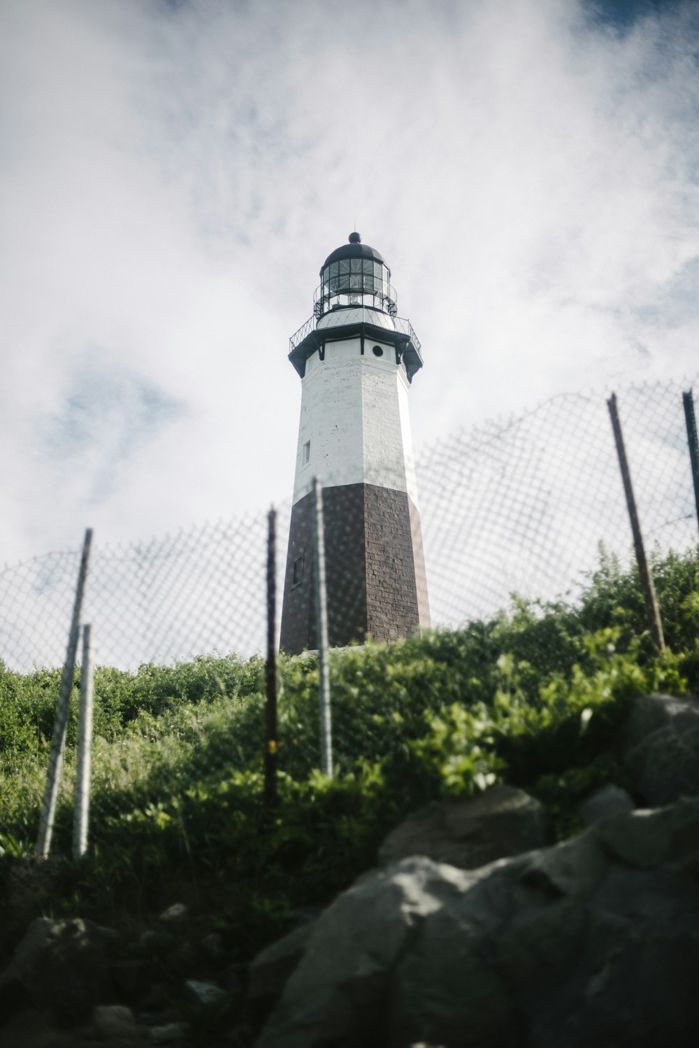 a black and white lighthouse sitting on top of a hill