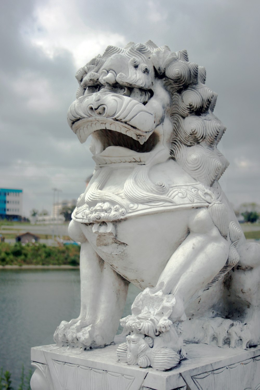 a statue of a lion sitting on top of a cement block