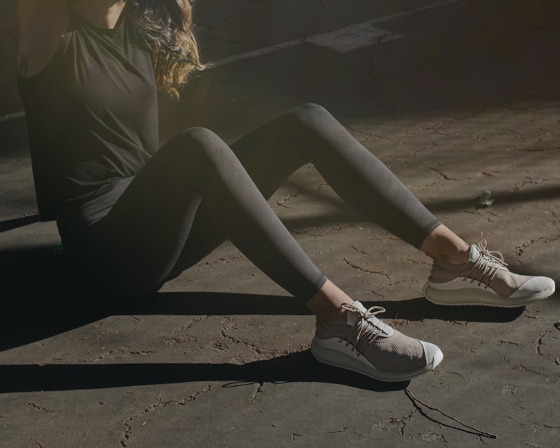 a woman sitting on the ground with her legs crossed