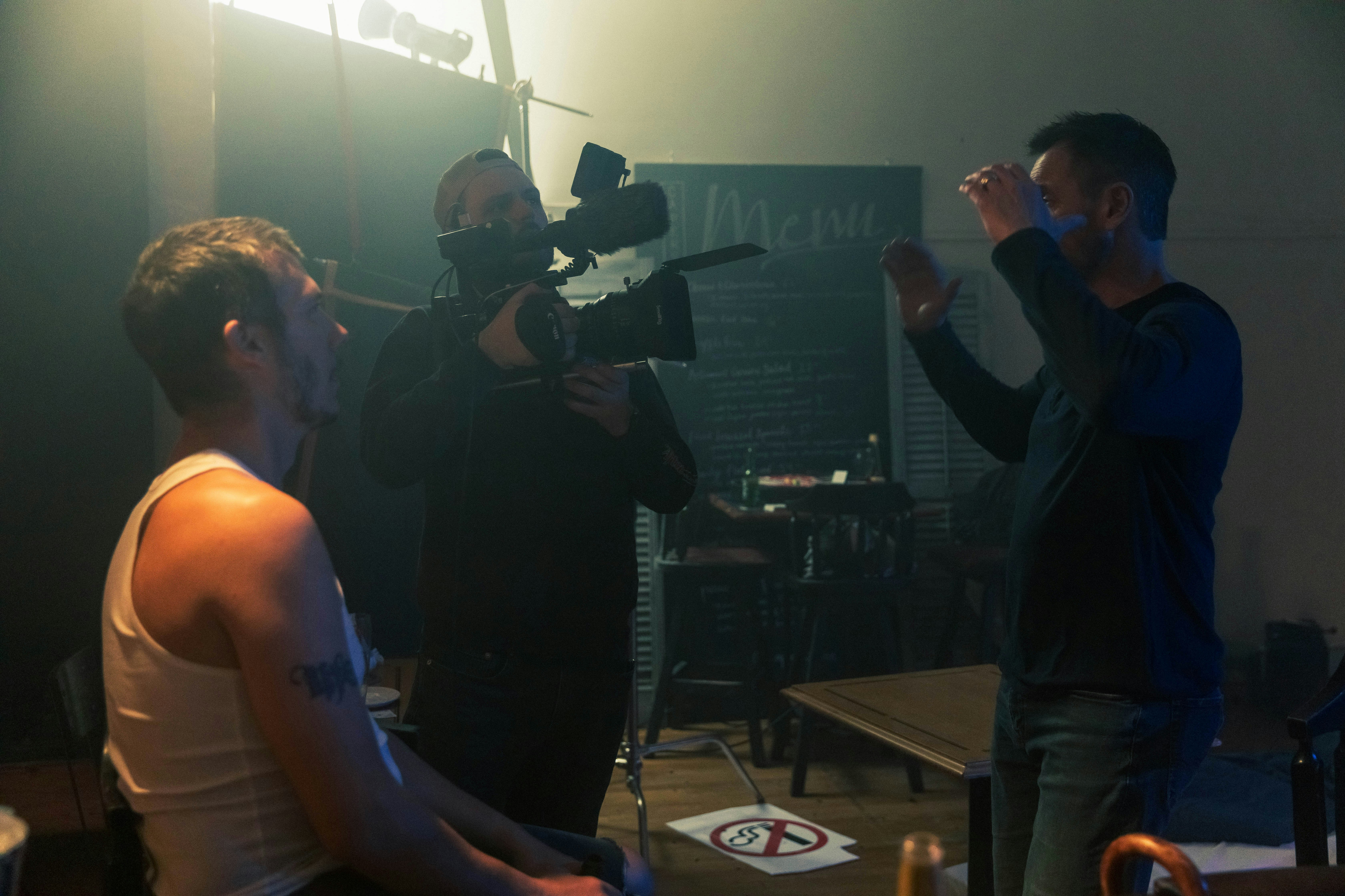 Eine Gruppe von Männern, die um eine Kamera in einem Raum stehen