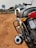 a motorcycle parked on the side of a dirt road