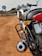 a motorcycle parked on the side of a dirt road