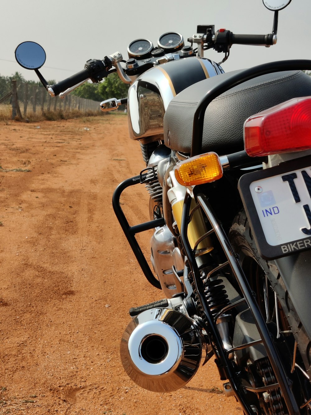 a motorcycle parked on the side of a dirt road